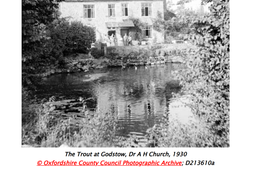 a pub on the bank of a river, water in the foreground.